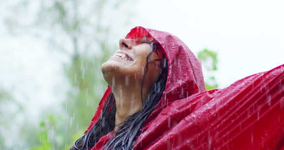 女孩在雨中微笑和大笑。雨落下，水滴落在他