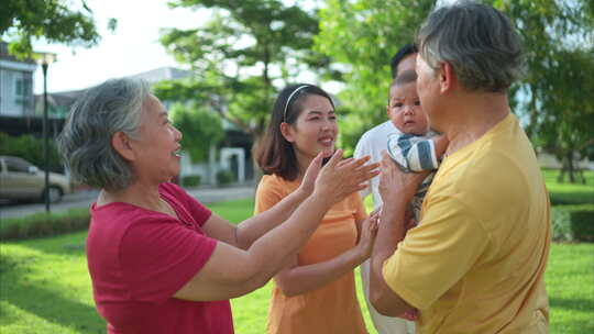 祖父母和带着小孩的父母正在公园里玩得开心