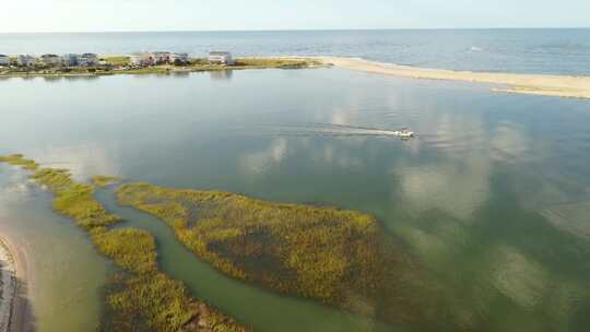 北卡罗来纳州橡树岛的鸟瞰图。一艘渔船沿着水道行驶的景色