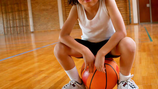 小孩坐在篮球上