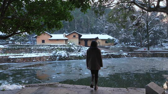 雪后跟拍美女游客行走在毛泽东故居前