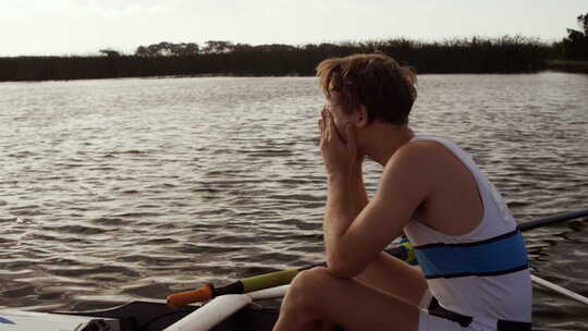 男性划手在湖上的船上哭泣