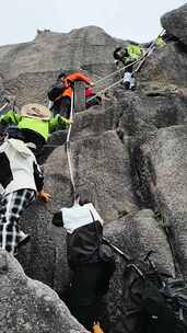 登山者借助绳索攀爬天都峰