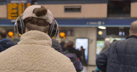 火车站里戴着耳机的男人
