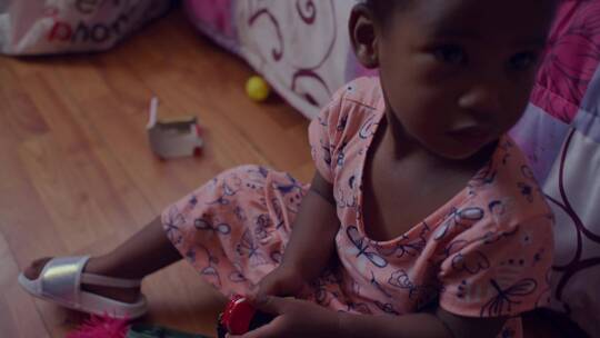 一个小女孩坐在地板上玩玩具
