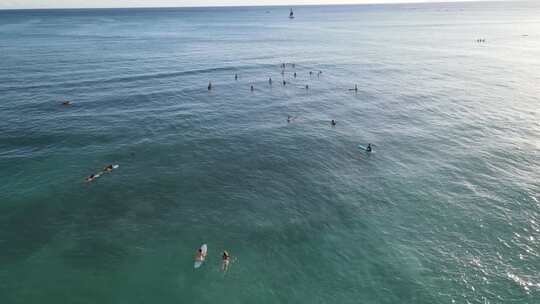 一望无际的大海上一群冲浪爱好者在海里冲浪