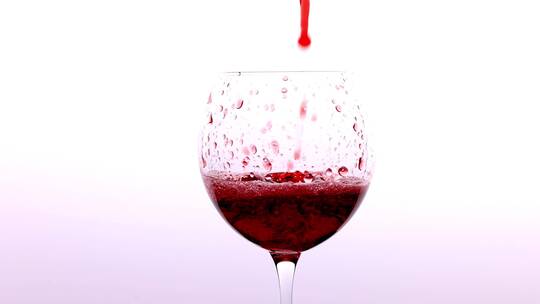 鲜红的红酒倒入酒器高脚杯过程特写