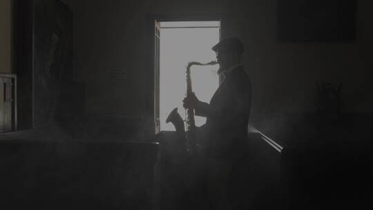 萨克斯管演奏者在黑暗的房间里演奏的剪影