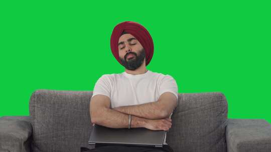 昏昏欲睡的锡克教印度人使用笔记本电脑绿屏