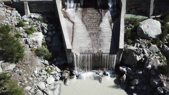 瑞士阿尔卑斯山一座石头水电站后的山间湍流瀑布，能源工业视频素材模板下载