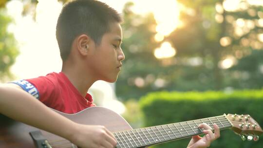 夕阳下弹吉他的小男孩，暑假生活视频素材模板下载