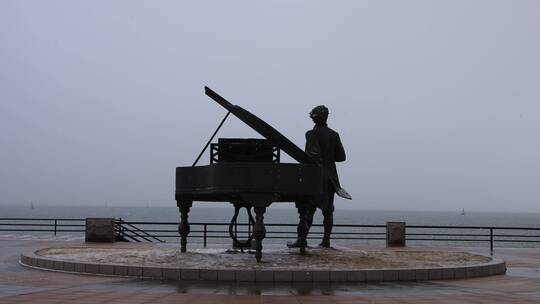 雪花纷飞之中的海上钢琴师雕像威海