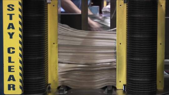 工厂里装订报纸的机器视频素材模板下载