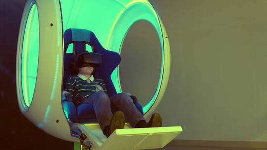 小男孩在移动椅子上享虚拟现实