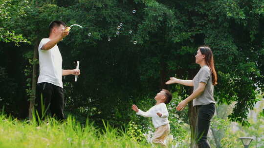 一家三口开心家庭在户外公园玩耍