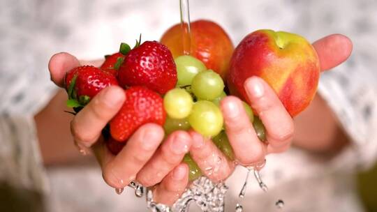 手牵着手冲洗草莓、苹果和葡萄