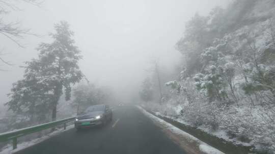 雪天雾气中汽车行驶在山路的特写