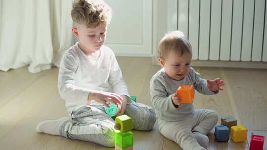 两个孩子玩彩色玩具积木