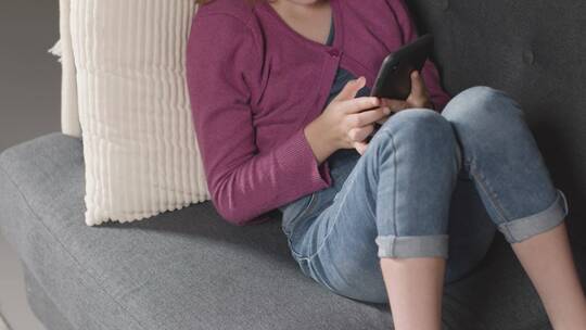 坐在沙发上玩手机的女人视频素材模板下载