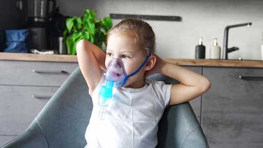 生病时，可爱的小女孩坐在家里，拿着雾化器