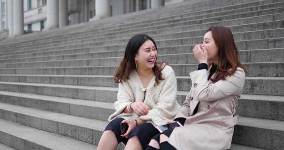 美女大学生闺蜜坐在台阶一起聊天友谊