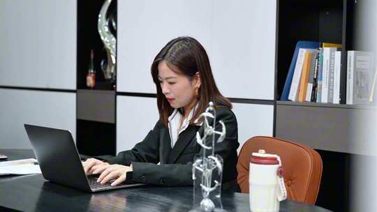 女白领办公室使用笔记本电脑办公