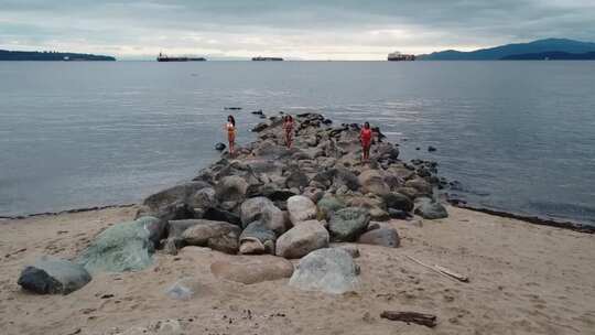 女人在岩石海岸做站立祈祷姿势