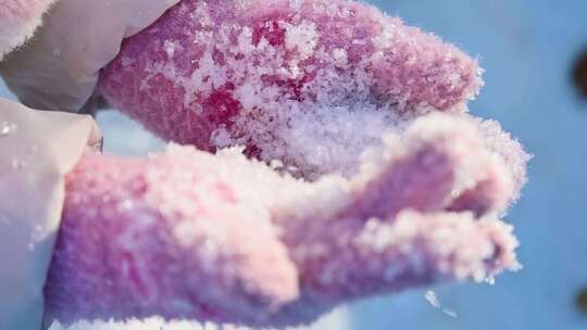 冬季阳光下儿童手捧雪花特写