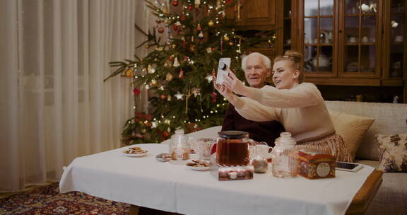 女孩和祖父在家里用手机自拍