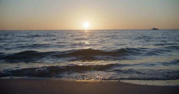 日出海景海浪拍打沙滩浪花大海夕阳海上游船