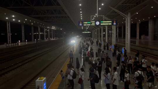 夜晚高铁站站台排队候车旅客列车进站