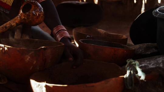 非洲妇女用勺子乘水