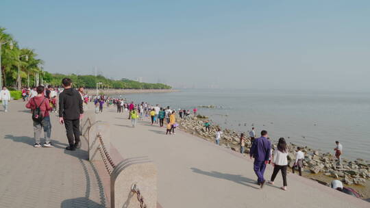 滨海边晴天蓝礁石市民游客绿道散步休闲