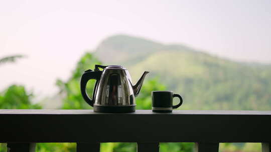 栏杆上的不锈钢茶壶杯茶时间风景山脉背景相