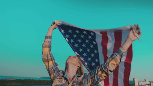 美丽的金发女人在挂着美国国旗的房子屋顶上视频素材模板下载