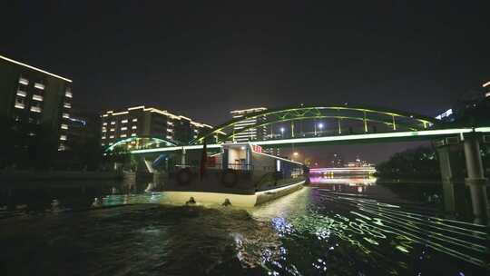 夜晚游船在城市河道中行驶