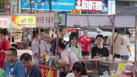 正在夜市小吃摊消费的年轻人