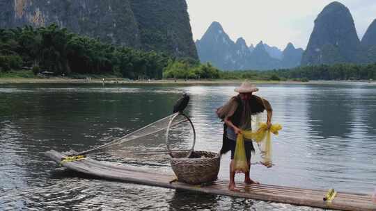 桂林漓江渔民在山水间撑竹筏撒网捕鱼的场景