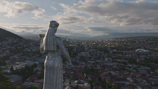 空中飞过第比利斯市的格鲁吉亚母亲雕像，日落时可以看到城市景观