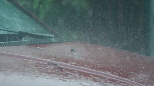 暴雨如注，雨水滴落在车前盖溅起水花视频