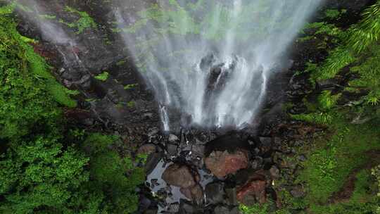 沿着热带雨林瀑布下降到下面的天然岩石池。