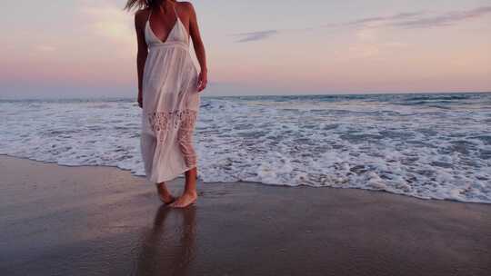 迷人的女人在日落时享受海滩
