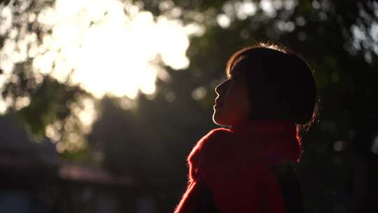 一个戴红色围巾的女人站在阳光下看远方风景视频素材模板下载