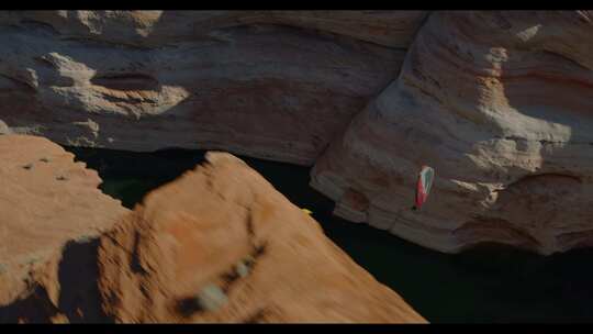 FPV无人机航拍动力伞在大峡谷河流上空飞行
