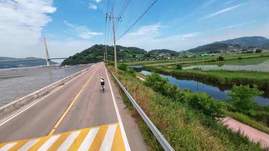 美女骑自行车公路森林高山蓝天白云