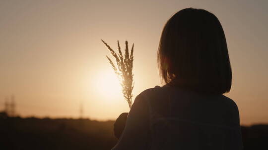 女人站在草地上看夕阳