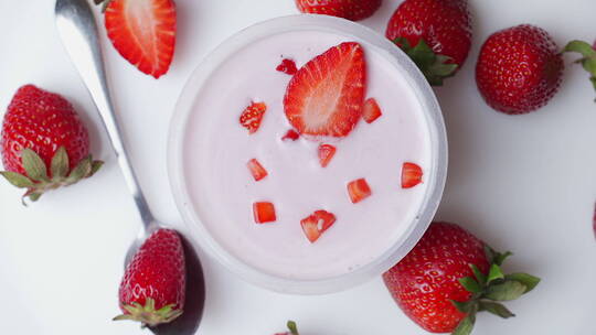 一碗美味的酸奶和草莓在桌子上旋转视频素材模板下载