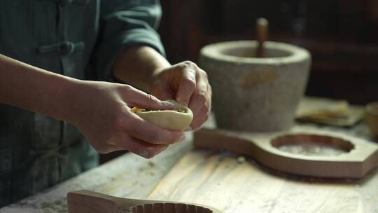 制作月饼过程中烘焙师包裹馅料