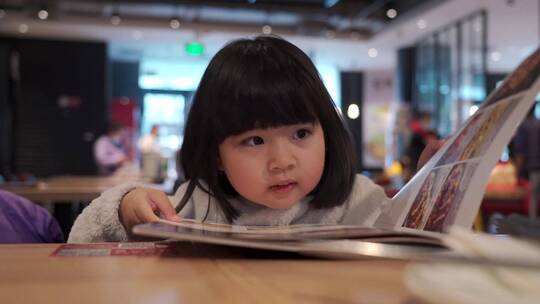 在餐厅翻阅菜单点餐的亚洲女孩