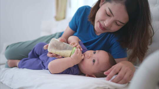 一位母亲哄她的小孩睡在房子客厅的沙发上